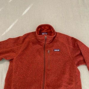 Long sleeve Patagonia full zip with three pockets. Burnt orange/ rust colored